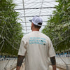 We Believe Shirt being worn in greenhouse surrounded by plants