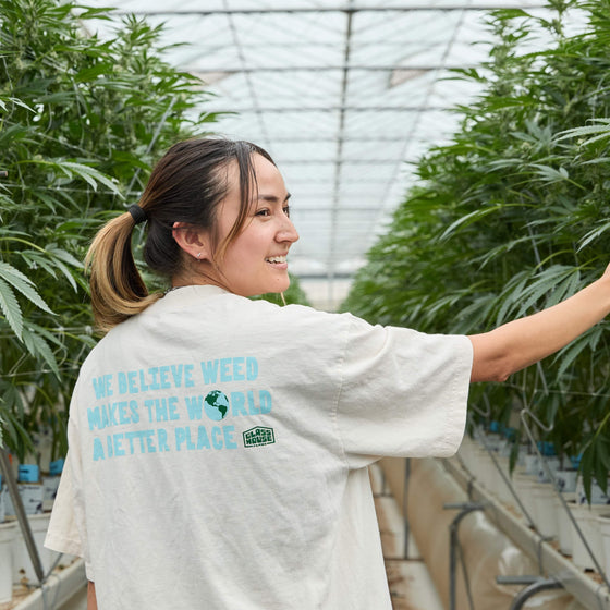 Team member in a  greenhouse wearing 'We Believe' Tshirt 